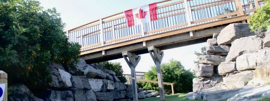 Wooden bridge over a mini golf hole with rock landscaping