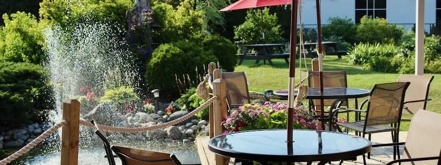 Patio umbrellas beside a fountain and garden seating area